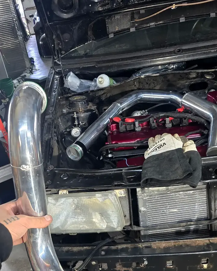 Charge-pipe test fit — Fabricated aluminum sections checked against the engine-bay route before final assembly.