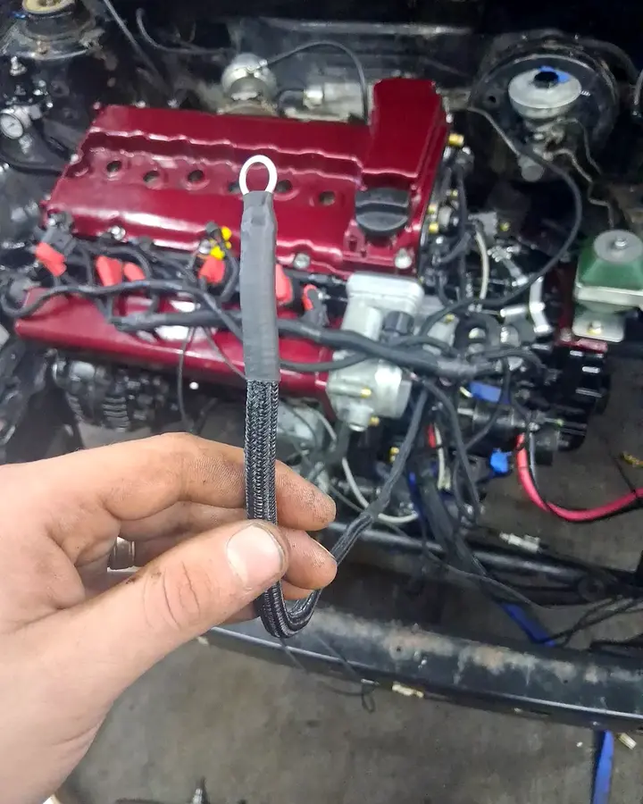 Standalone wiring detail — A protected engine-bay lead prepared as part of a larger wiring workflow.